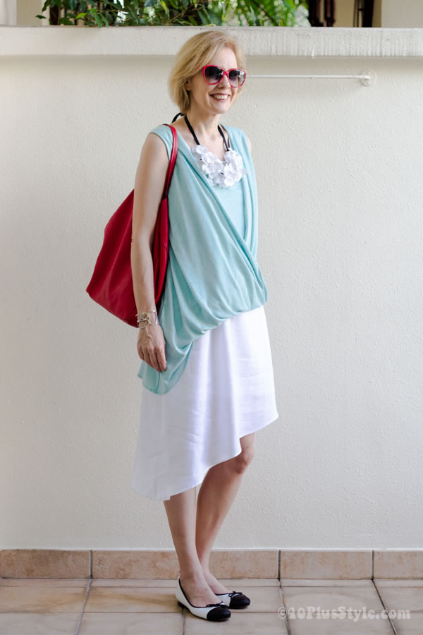 Asymmetrical dress with asymmetrical top and white flower necklace | 40plusstyle.com