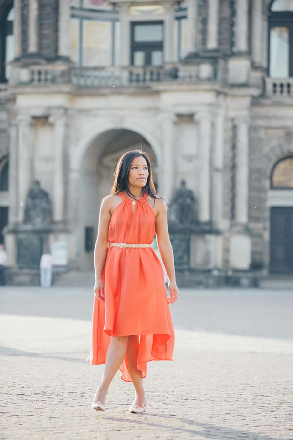 Souri wearing an orange asymmetrical dress | 40plusstyle.com