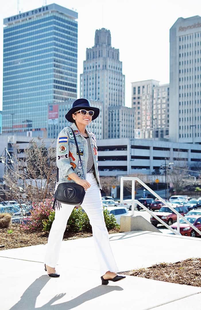 Carelia wearing patched denim jacket and white pants | 40plusstyle.com
