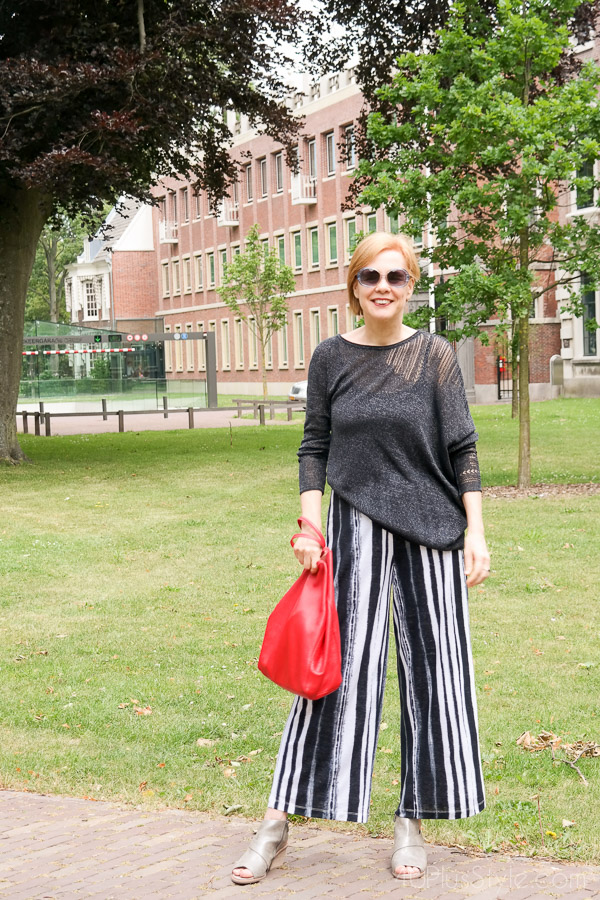 Striped pants with and asymmetrical top make a stylish look! | 40plusstyle.com