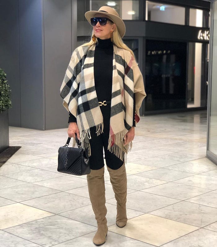 Nadine wearing a knitted ruana over a turtleneck with pants and high boots | 40plusstyle.com