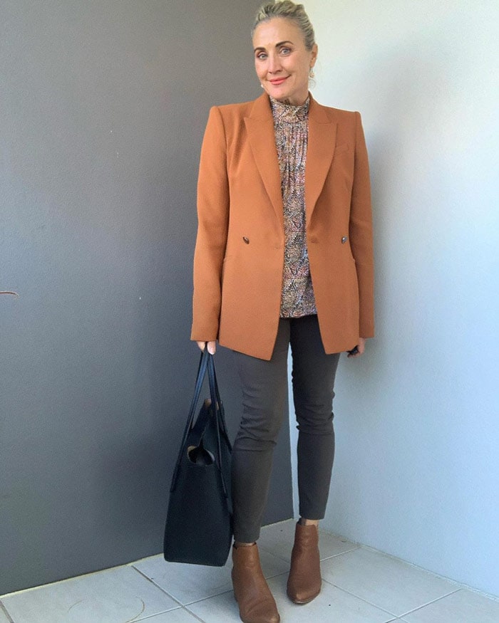 Melinda wears and orange blazer and tan booties for fall | 40plusstyle.com