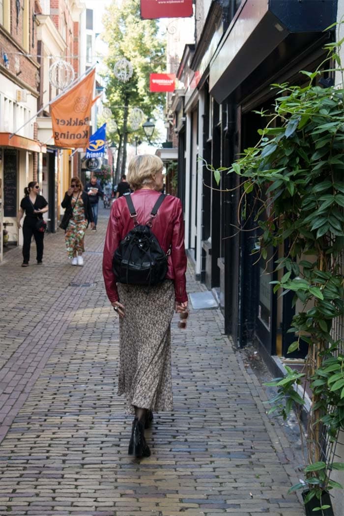 Wearing a backpack over red leather jacket and long skirt | 40plusstyle.com