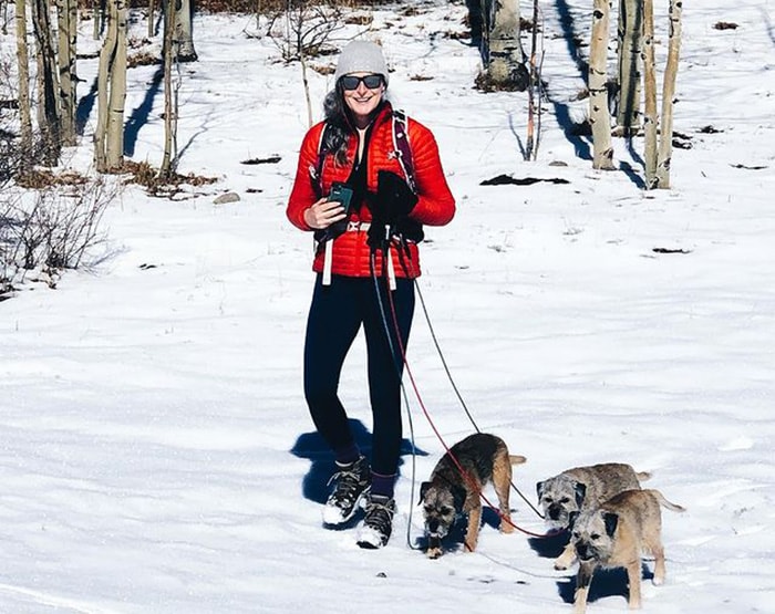 Amanda wears a bright red coat for a walk with her three dogs | 40plusstyle.com