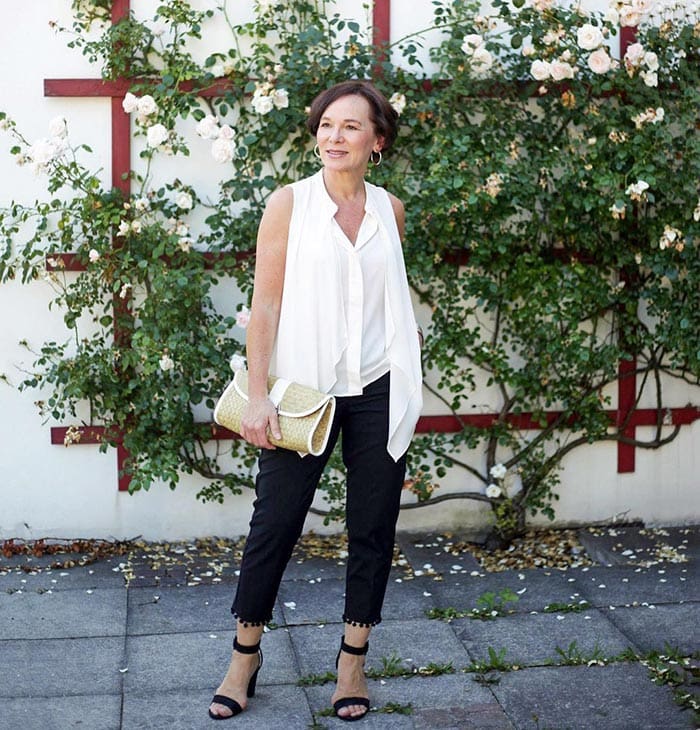 Annette wears her black jeans with a white shirt and rattan handbag | 40plusstyle.com