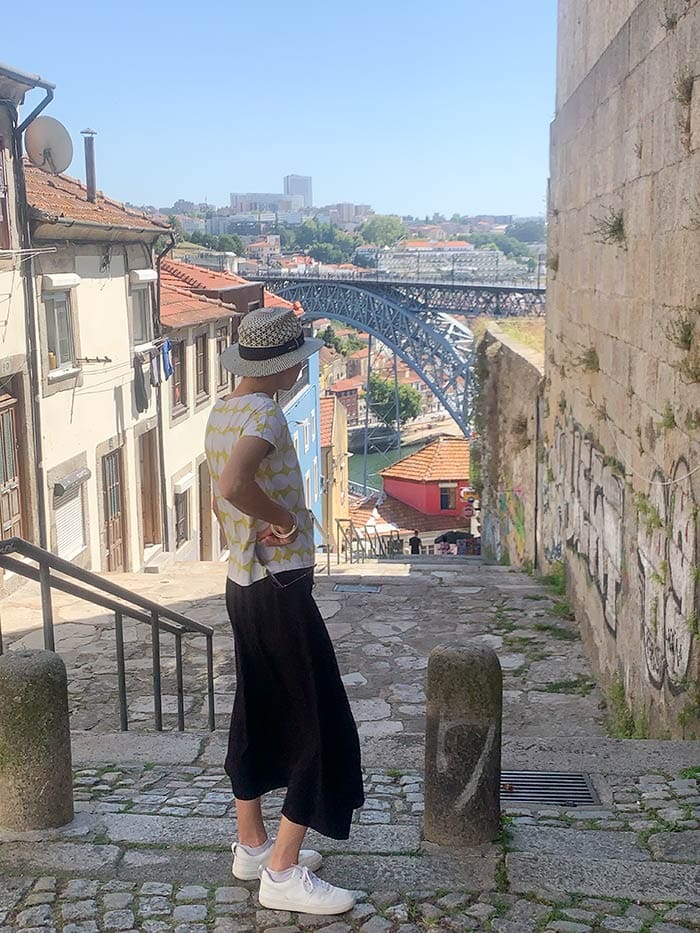 Wearing a black skirt, graphical t-shirt and sneakers in Porto, Portugal | 40plusstyle.com