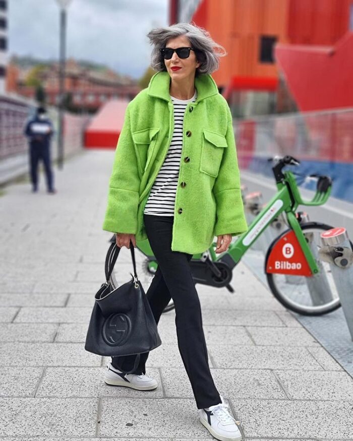 Carmen in green coat, striped sweater, straight leg pants, sneakers and tote | 40plusstyle.com