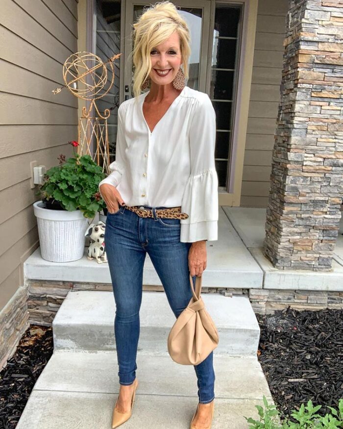 Clothes for older women - Melanie in a V-neck blouse, jeans and neutral accessories | 40plusstyle.com