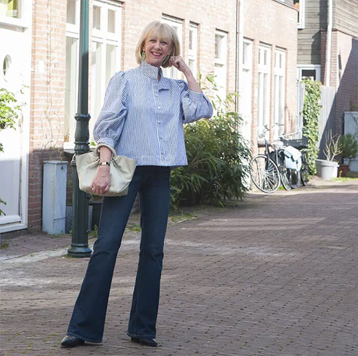 Greetje wears flare jeans and a striped shirt | 40plusstyle.com
