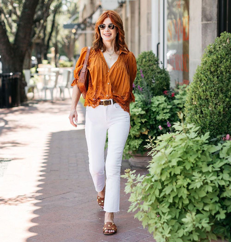 Cathy wears an orange blouse with her jeans | 40plusstyle.com