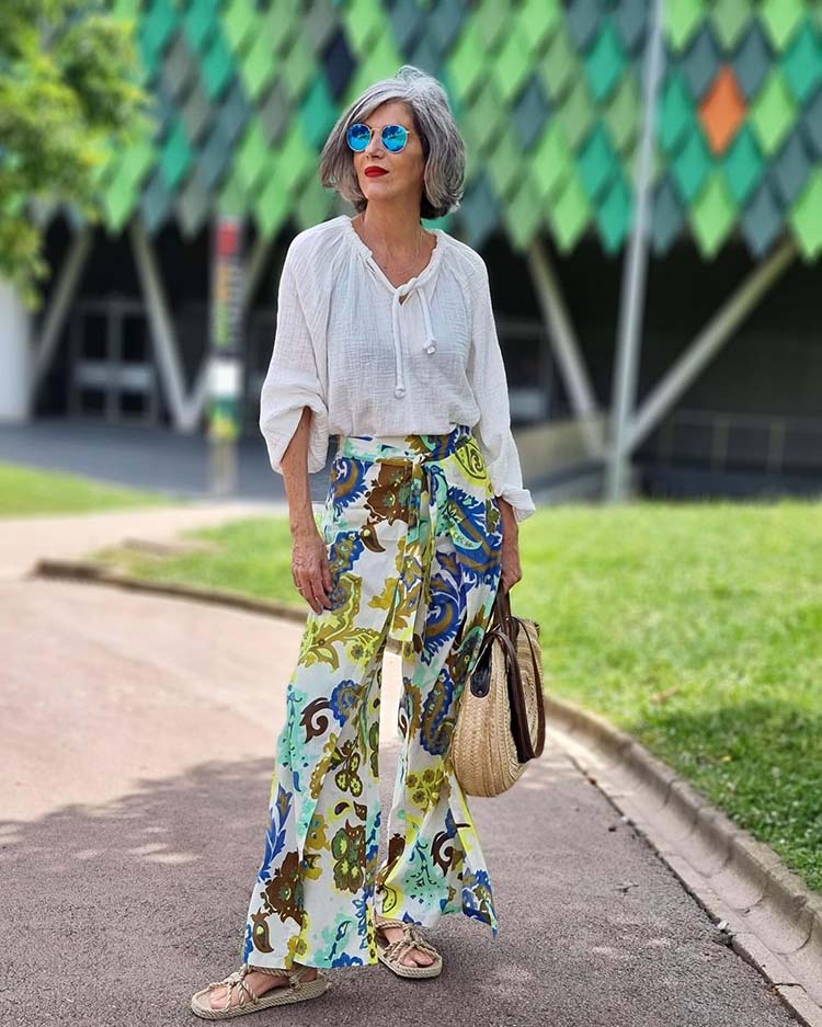Carmen wears a white top and print pants | 40plusstyle.com