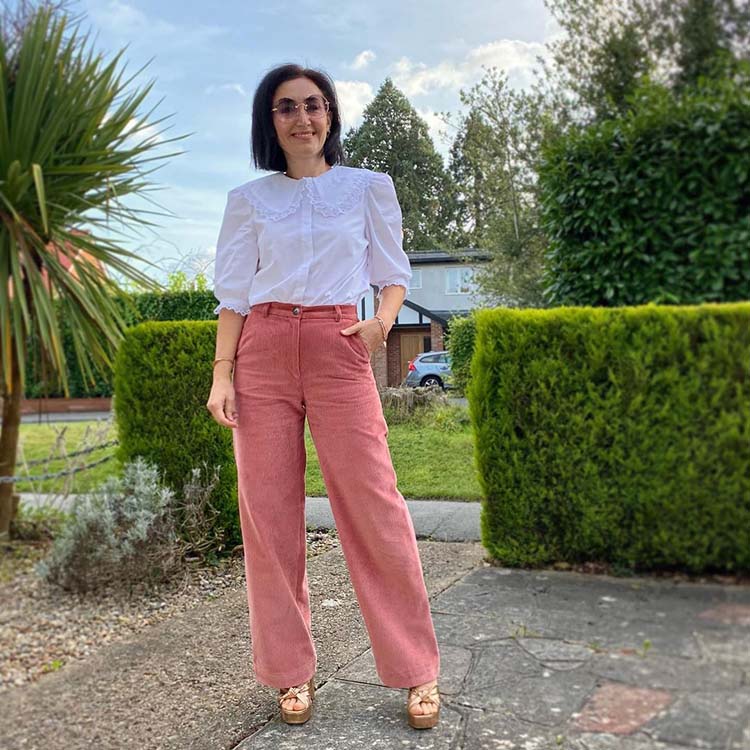 Emms wears a white blouse and pink pants | 40plusstyle.com