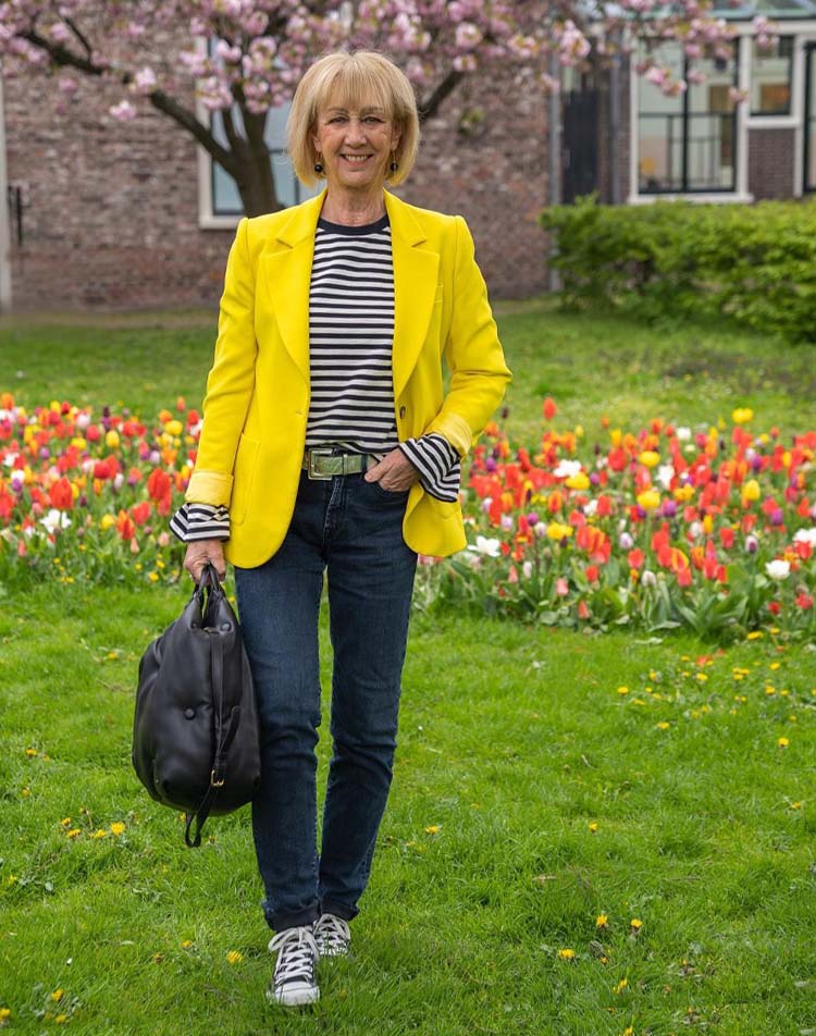 Greetje wears a yellow blazer and jeans | 40plusstyle.com