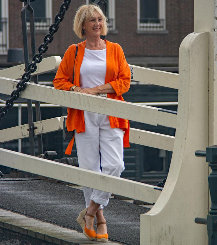 Greetje wears an orange and white outfit | 40plusstyle.com
