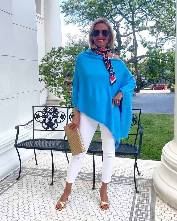 Nora wears a blue poncho and white jeans  | 40plusstyle.com