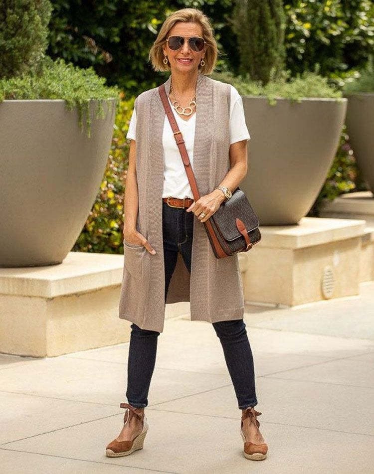 Nora wears a beige sleeveless vest with her jeans | 40plusstyle.com