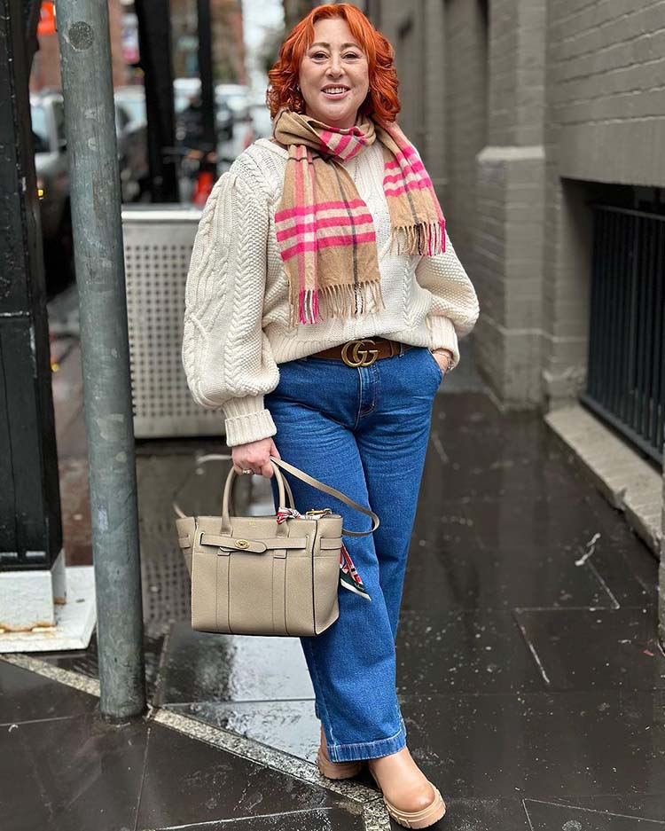 Sweaters for women: Kimba wearing a cable knit sweater, jeans and boots | 40plusstyle.com
