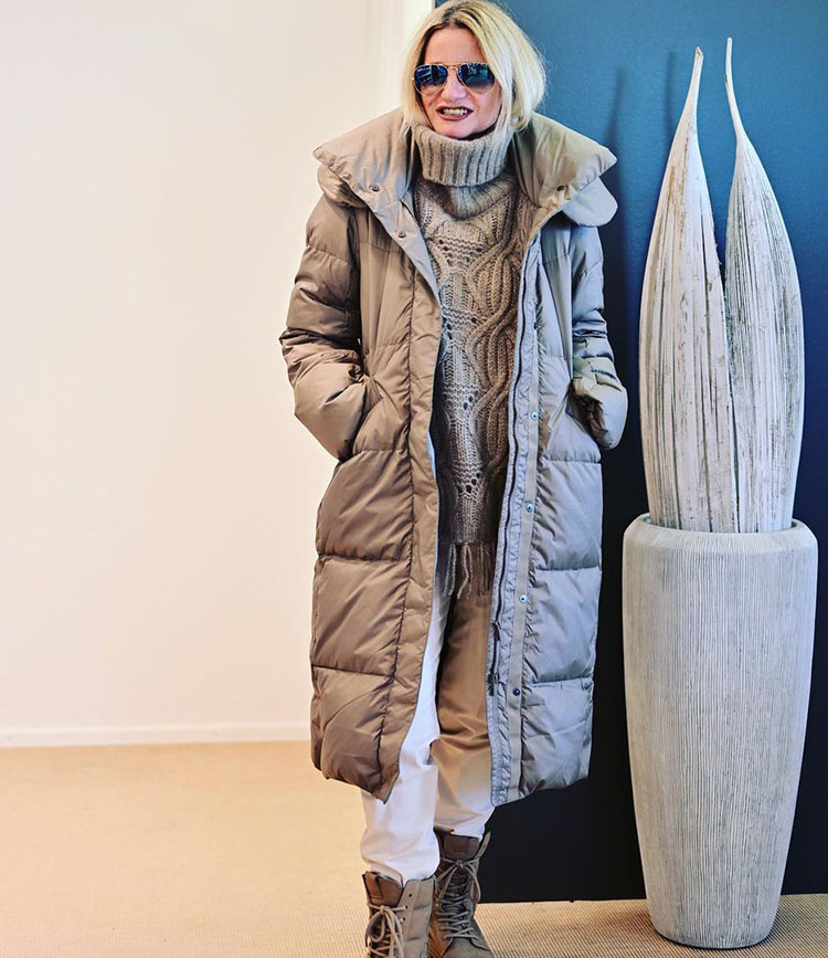 Yvonne in long puffer coat, cable knit sweater, pants and high boots | 40plusstyle.com