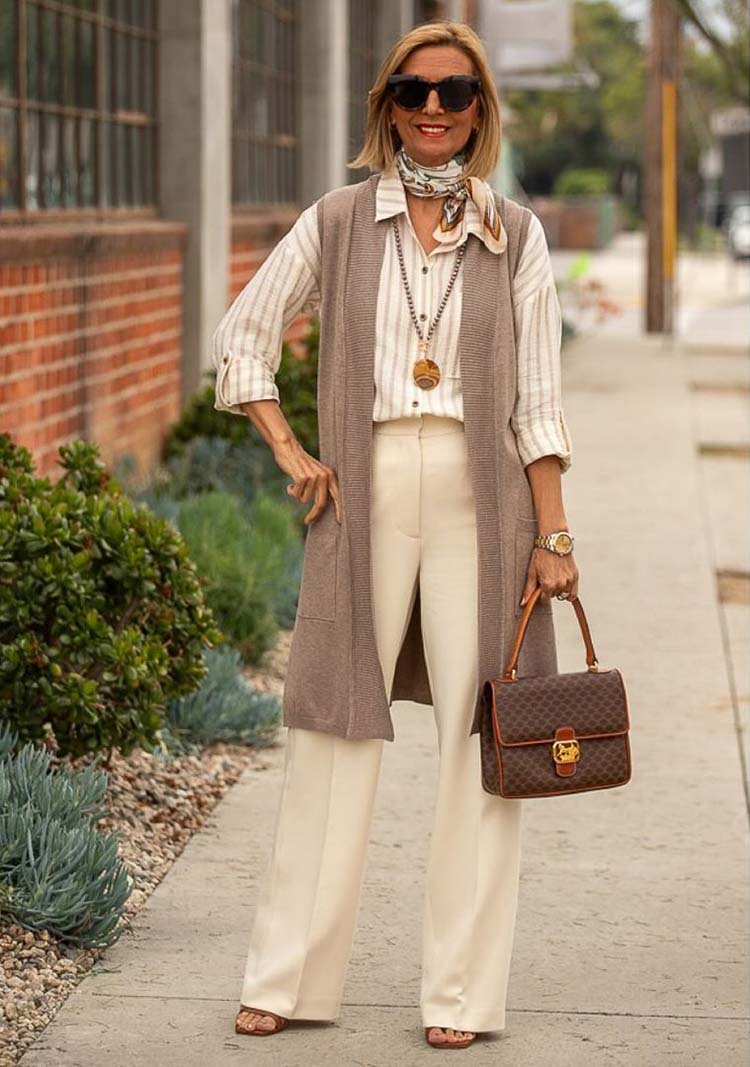 How to wear a long vest: Nora in a long knitted cardigan, shirt and trousers | 40plusstyle.com