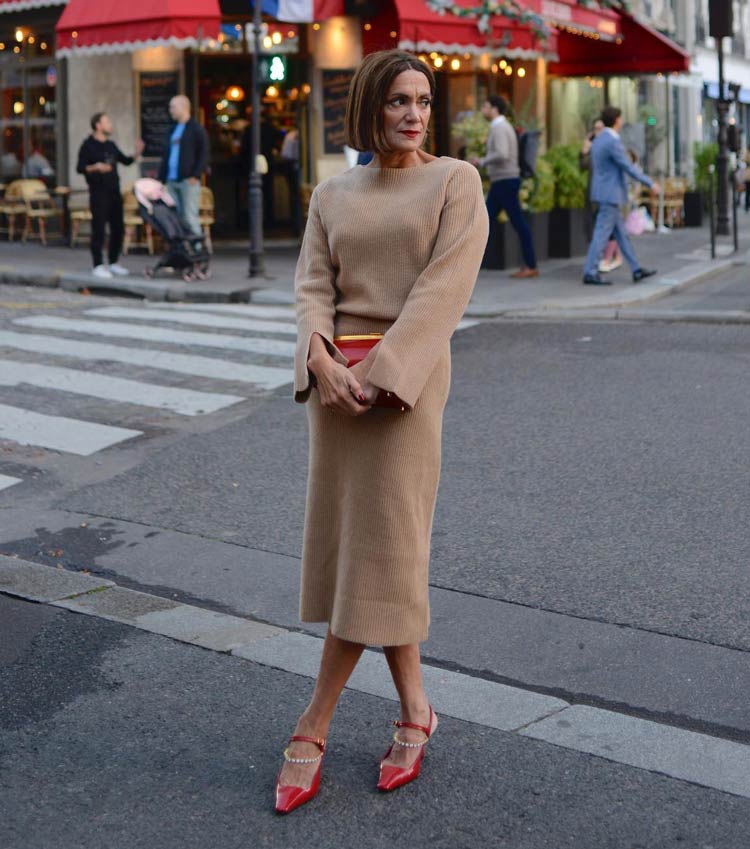 Sylvia wears a beige dress with red accessories | 40plusstyle.com