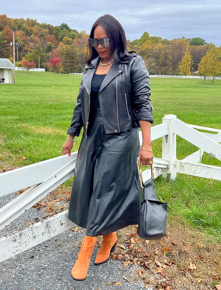 Eugenia wears a black outfit with orange boots | 40plusstyle.com